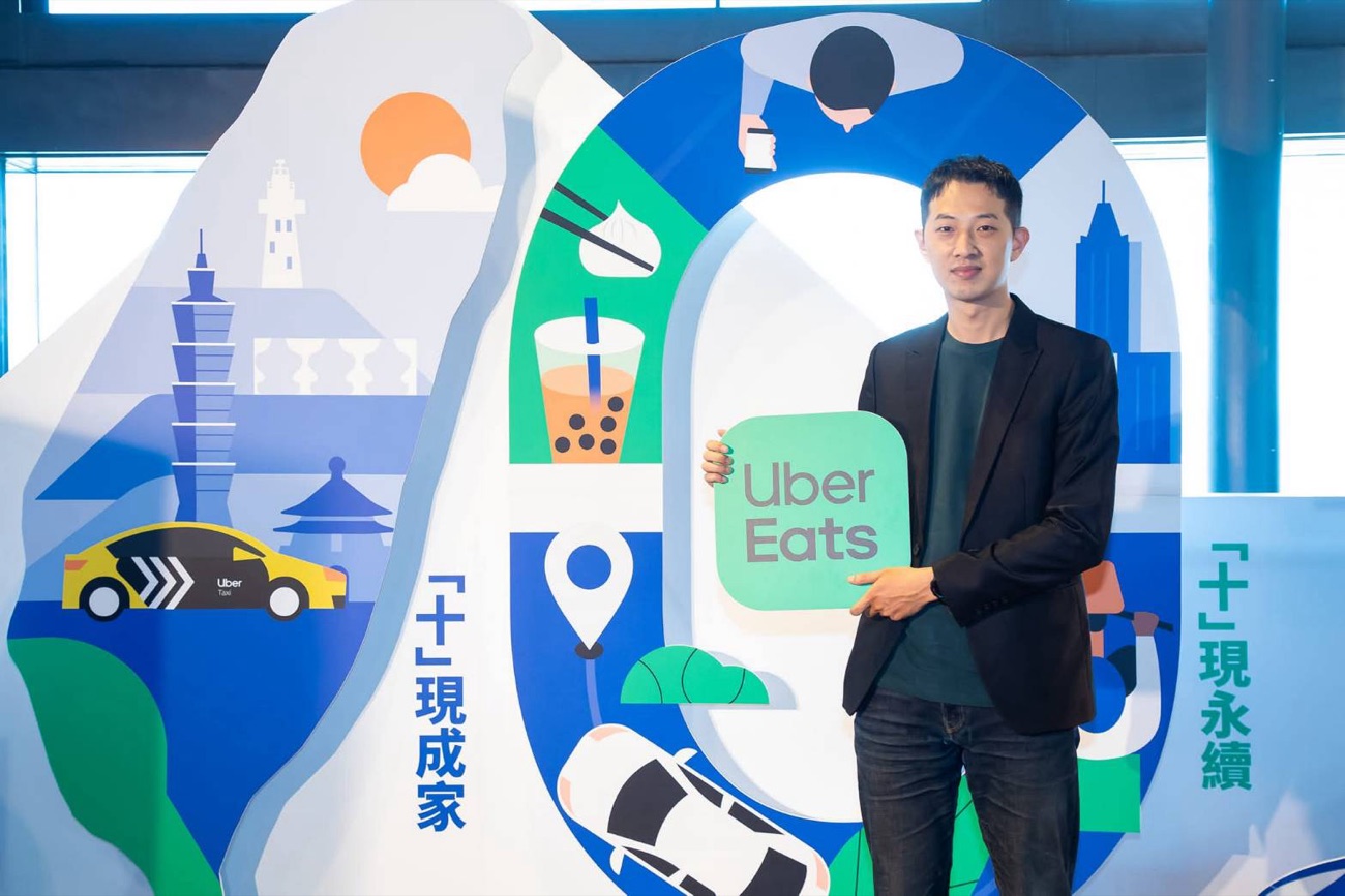 Eric holding an Uber Eats sign at an event display.